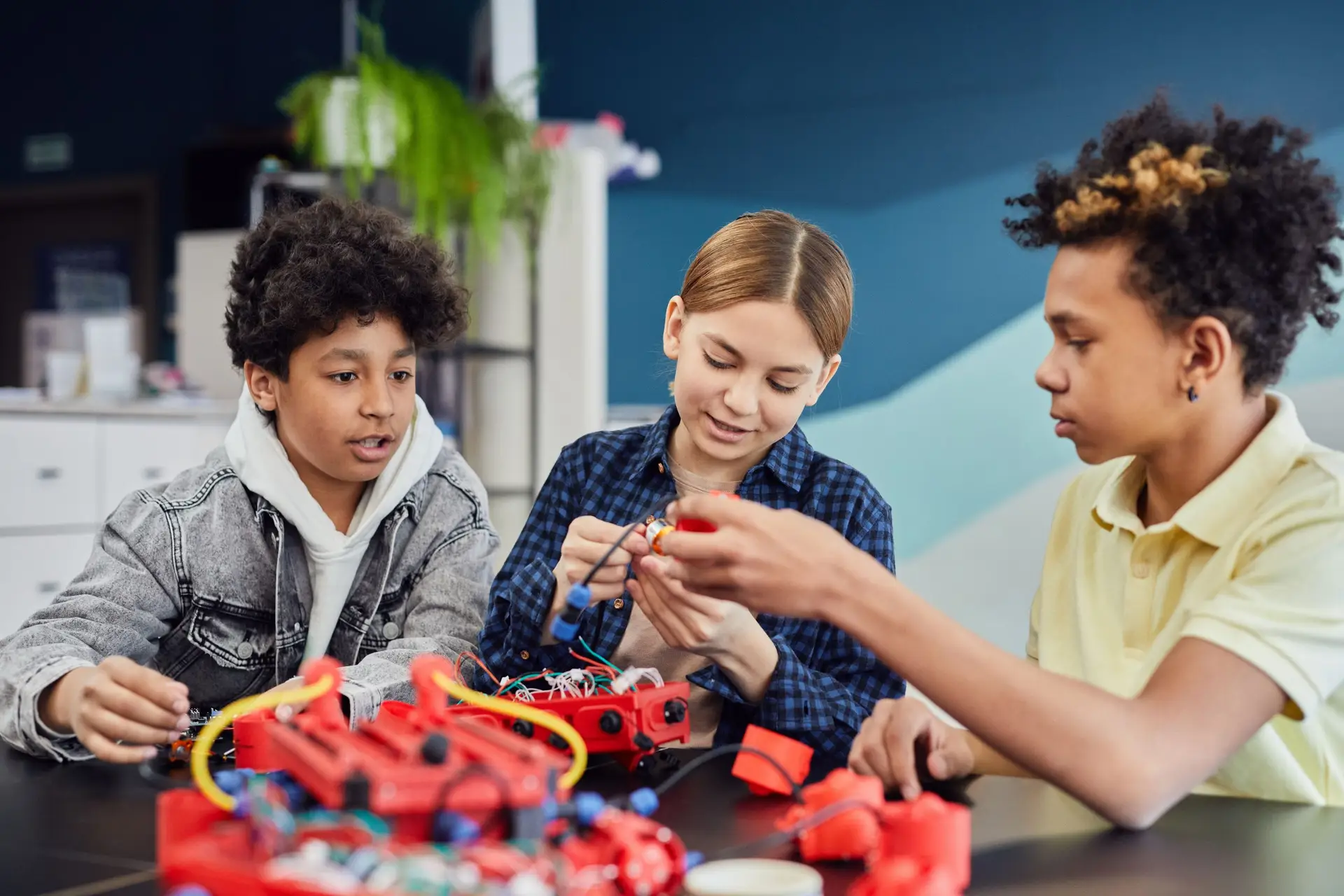Three kids working on a project, creating something
